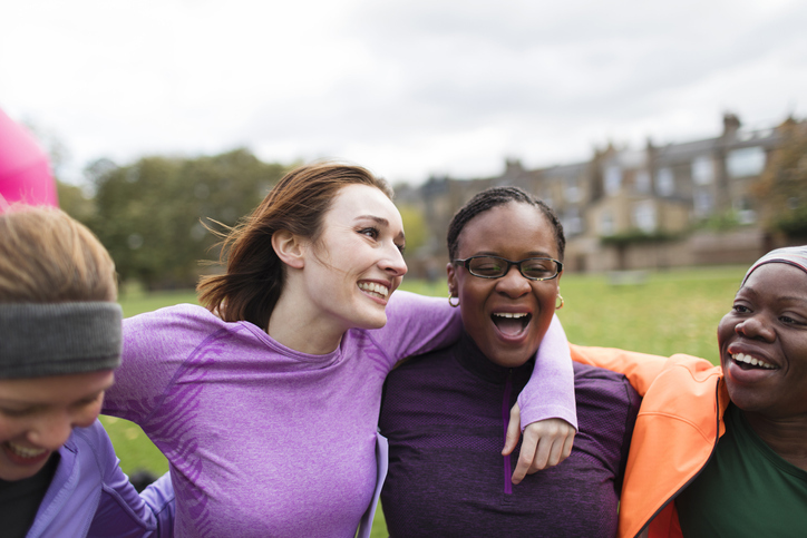 Group of women smiling with arms around each other 