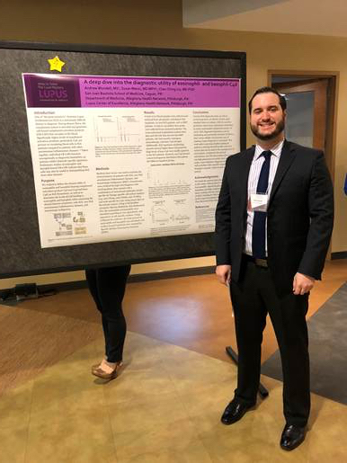 Andrew Blundell standing next to his scientific poster