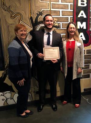 Andrew Blundell holding his award certificate