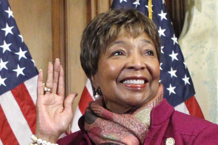 Former Texas Rep. Eddie Bernice Johnson holds up her hand in front of an American flag.
